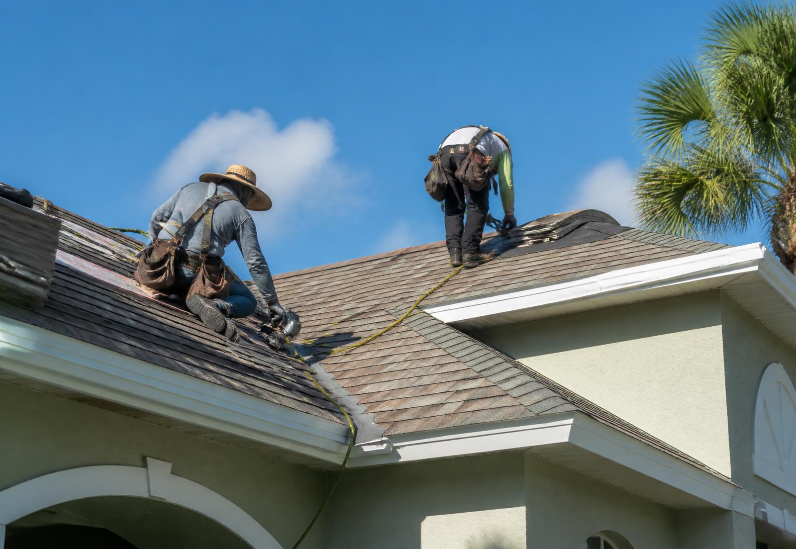 Roofers professionally installing shingles on a Florida home